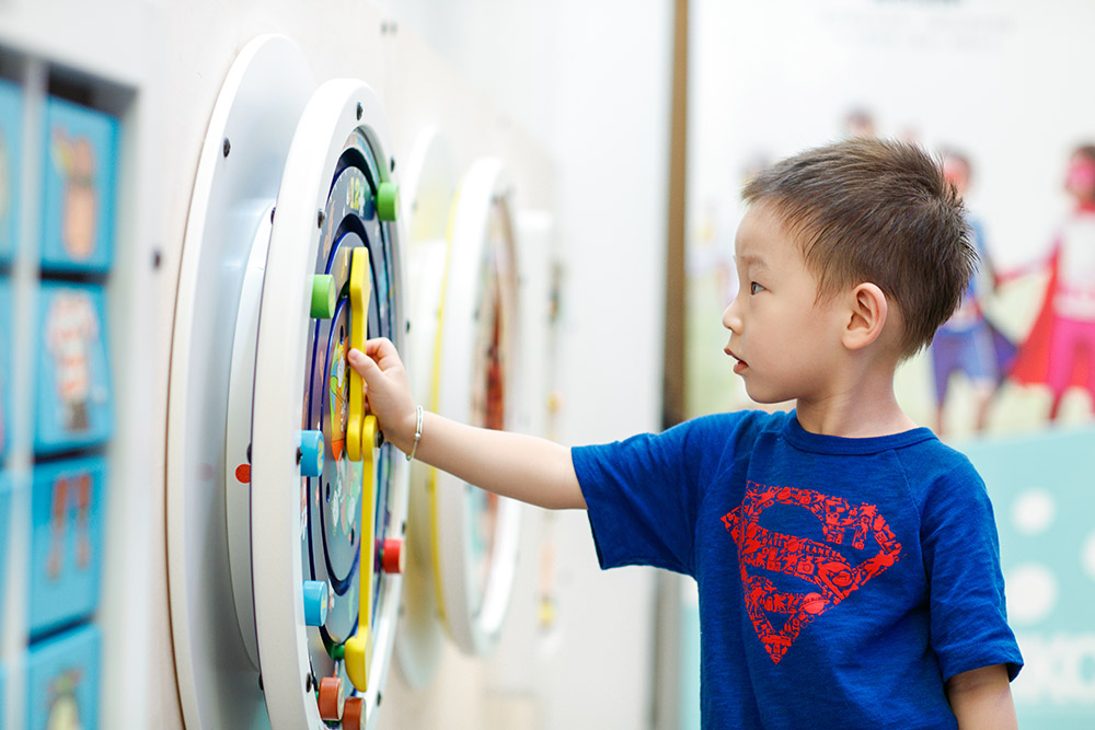 Kind spielt mit einem Wandspiel | IKC Play Kind spielt mit einem Wandspiel | IKC Play