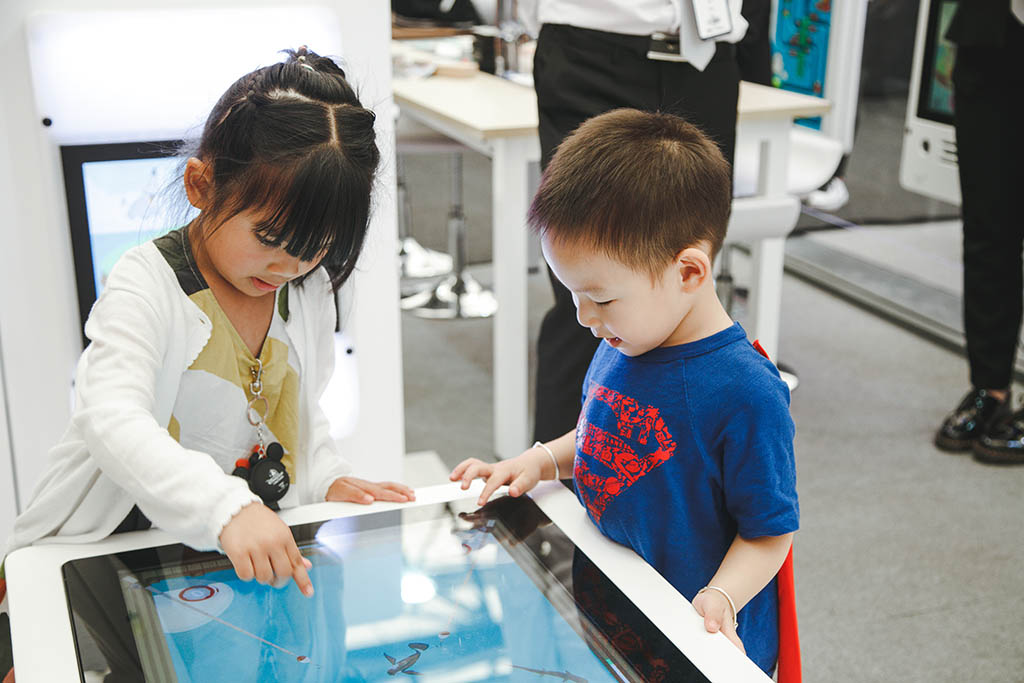 Zwei Kinder spielen fleißig mit den interaktiven Spielsystemen des IKC