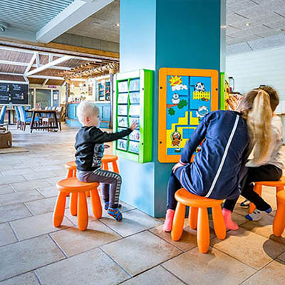 Kinder spielen in der Spielecke des Restaurants, während die Eltern essen können