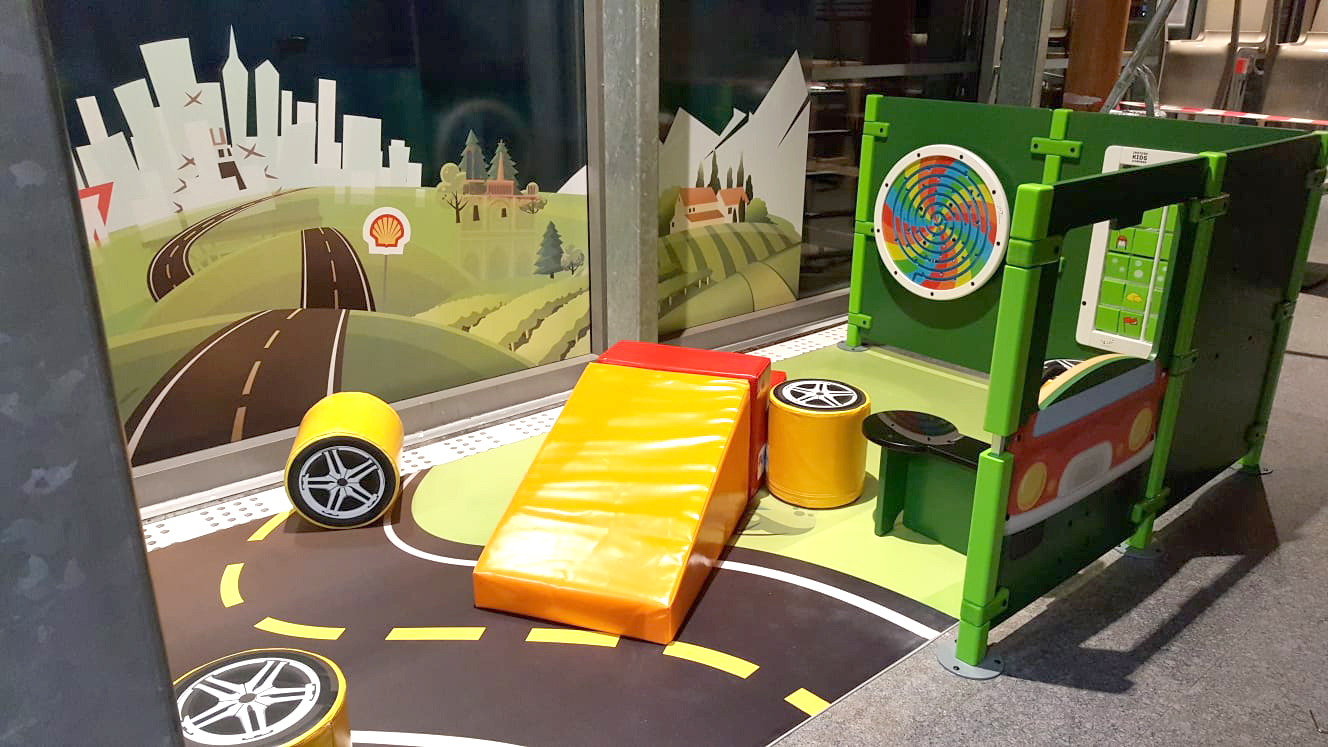 Spielecke für Kinder an einer Shell-Tankstelle in Frankreich mit verschiedenen Spielmodulen und Wandspielen