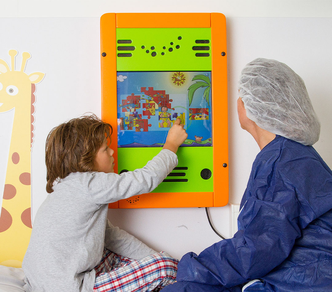Kind und Betreuer spielen mit Wandspiel im Krankenhaus Kind und Betreuer spielen mit Wandspiel im Krankenhaus