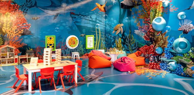 Spielecke mit Wandspielen, einer Kletterwand und Kindermöbeln Spielecke mit Wandspielen, einer Kletterwand und Kindermöbeln