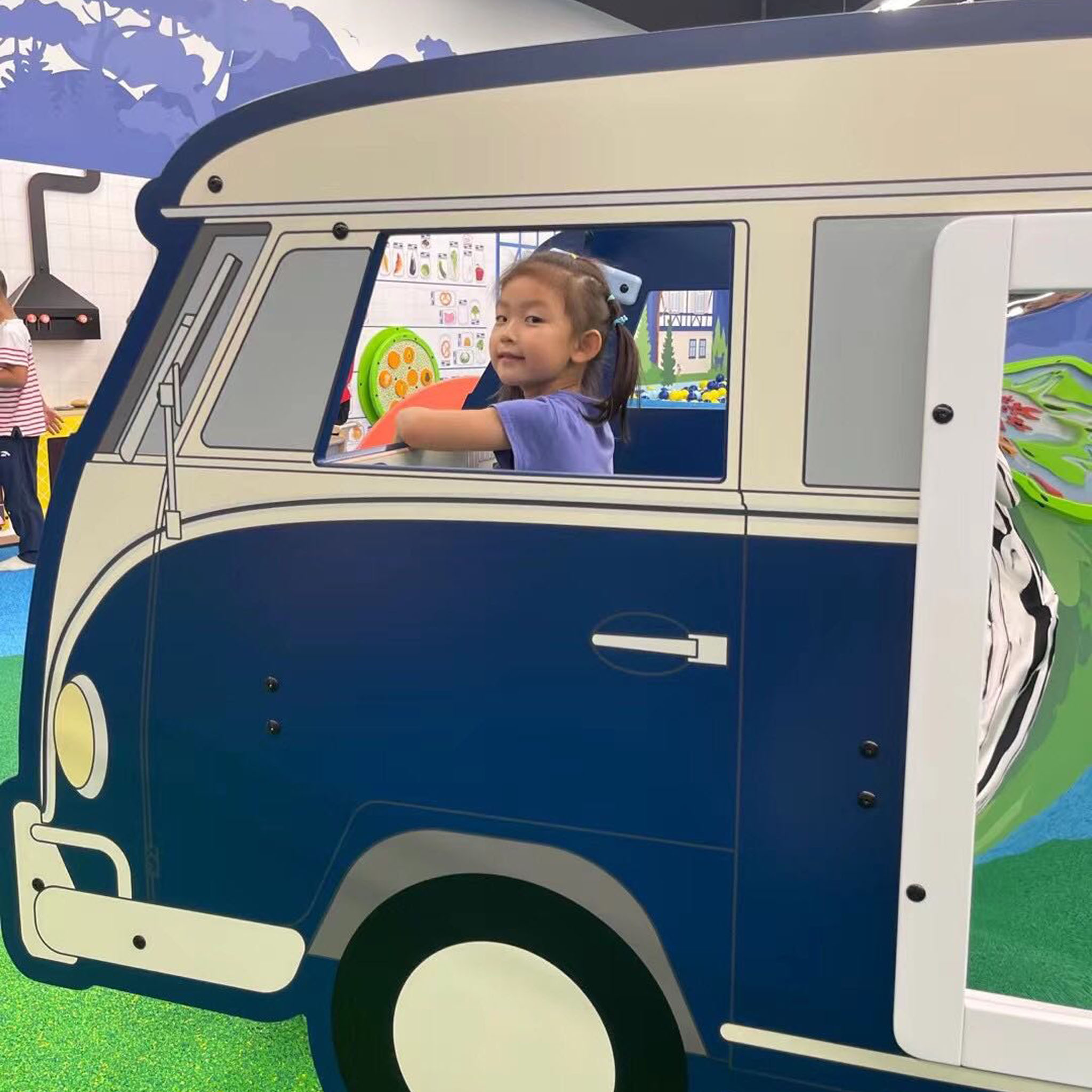 IKC Van Kids Corner A young girl playing in a play system from IKC in the form of a van